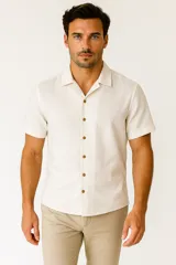 Camisa de lino color beige, de corte holgado, con cuello tipo solapa, manga corta y botones marrones.