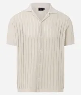Camisa de manga corta para hombre con cuello solapa y cierre frontal de botones. Presenta un diseño de punto con textura de líneas verticales en color beige y calce regular. Confeccionada en una mezcla de poliéster y algodón sustentable.