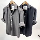 Camisa de vestir de algodón peletizado color azul grisáceo, de manga larga con puños abotonados y cuello clásico.