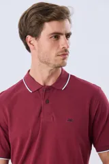 Remera polo de piqué azul marino, con cuello y puños de mangas cortas con ribete blanco en contraste, cierre frontal de dos botones y pequeño logo bordado en el pecho.