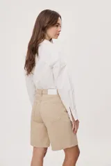 Bermuda de denim azul con calce relajado, tiro medio y largo hasta las rodillas. Cuenta con bolsillos clásicos y trabillas para cinturón.