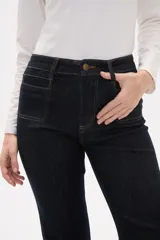 Pantalon de jean azul oscuro con corte flare, tiro alto y bolsillos frontales tipo parche.