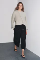 Chaqueta de lana 100% color gris claro, con cuello redondo, manga larga y cierre frontal con botones.