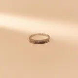 Anillo de diseño entrelazado fabricado en oro de 18k, combinando bandas en oro amarillo y oro blanco con incrustaciones de circonias.