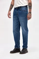 Jean de corte tapered, holgado en la cadera y levemente ajustado hacia los tobillos, con tiro medio y lavado azul clásico.