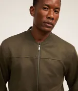 Chaqueta bomber masculina de color verde militar, confeccionada en poliéster con un toque de elastano, diseño liso, cuello mao y cierre frontal de cremallera.