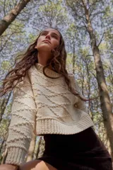 Sweater crop de tejido de punto con diseño de rombos en relieve, cuello redondo y terminaciones acanaladas en puños y ruedo.