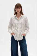 Camisa de viscosa con estampado de rayas verticales, cuello camisero, cierre frontal con botones y mangas largas.