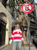 Sweater de algodón a rayas horizontales rojas y blancas, con cuello polo y cierre parcial con botones.