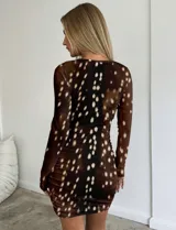 Vestido corto de manga larga con diseño ajustado y fruncido en la parte frontal. Presenta un estampado animal print que simula el pelaje de un ciervo en tonos marrones con manchas blancas.