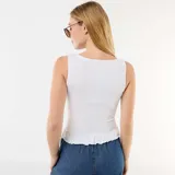 Musculosa blanca de tejido elástico tipo smock, sin mangas, con cuello redondo y dobladillo con volados.