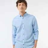 Camisa de manga larga en color azul cielo, confeccionada en mezcla de lino con botones frontales imitación madera y cuello con botones.
