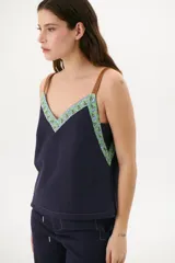 Musculosa azul marino de lino con escote en V, breteles de cuero marrón y pespuntes blancos decorativos.