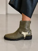 Bota corta de cuero negro con punta cuadrada, taco bajo y detalle de aplique metálico dorado en el lateral. Cuenta con cierre posterior y diseño de estilo sport.