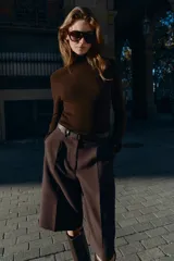 Bermuda larga color marrón oscuro, tiro medio, con pinzas frontales y cinturón de textura animal print plateado.