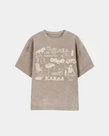 Remera de algodón con efecto stone wash, corte oversize y estampa frontal con múltiples gráficos estilo collage.