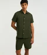 Bermuda masculina de corte recto, confeccionada en algodón con textura de cuadros verticales sutiles. Presenta cintura elástica con cordón ajustable y bolsillos laterales.