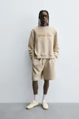 Bermuda de algodón color beige, estilo jogger, con corte relajado, cintura elástica ajustable con cordón y bolsillos laterales y trasero.