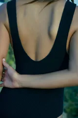 Traje de baño entero negro de tela texturada, con escote redondo y espalda cavada en U.