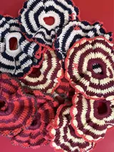 Colita de pelo tejida a crochet con hilo de algodón en color crema y borgoña, con borde rosa.