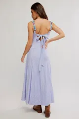 Vestido largo con diseño a rayas celestes y blancas, tirantes anchos, escote cuadrado y bolsillos frontales. Cuenta con delicados detalles de bordado floral multicolor en el pecho, tirantes y bolsillos.