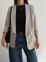 Blazer sastrero de corte clásico con solapas frontales y bolsillos con solapa. Presenta mangas largas con puños vueltos y un diseño forrado que ofrece una caída estructurada y elegante.