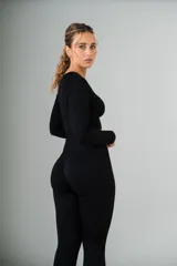 Conjunto deportivo color borgoña, compuesto por calzas largas de tiro alto y top crop de manga larga. Ambos de tejido acanalado.