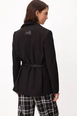Blazer de largo medio con terminaciones clásicas, diseño sin cruce frontal y cinto de cuero fino incorporado para ajuste en la cintura.