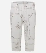 Pijama de dos piezas compuesto por una blusa de manga corta con escote en V decorado con encaje y un pantalón estilo capri con cintura elástica y terminaciones de encaje en el ruedo. Presenta un estampado floral delicado sobre fondo claro.