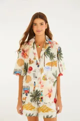 Camisa de lino y algodón color crudo con estampado de escenas de playa tropicales, de corte holgado, con cuello abierto y mangas cortas.