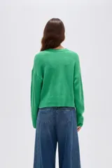 Cardigan de punto color marrón, con cuello en V profundo, cierre frontal con botones y diseño holgado de manga larga.