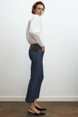 Jeans de mezclilla azul claro, tiro medio, corte recto y ligeramente acampanado en el bajo. Presenta cinco bolsillos y cierre frontal con cremallera y botón metálico.