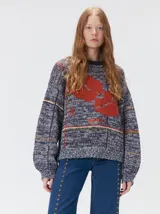 Sweater de punto con diseño geométrico y gráfico frontal en color rojo. Presenta cuello redondo, mangas largas holgadas y un ajuste suelto.