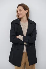 Trench coat negro de corte midi, con cuello solapa, cierre frontal cruzado con botones y cintas ajustables en los puños.