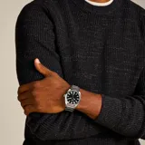 Reloj analógico Fossil Everett con caja de acero inoxidable de 42 mm y pulsera de eslabones a tono. Presenta una esfera negra con textura concéntrica, índices aplicados luminiscentes, manecillas plateadas y ventana de fecha a las seis. Movimiento de cuarzo con cristal mineral y resistencia al agua de 5 ATM.