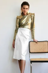 Falda midi blanca de cuero sintético, corte tubo tipo wrap, con lazo lateral. 