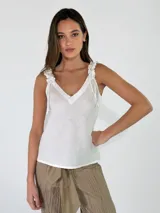 Top blanco sin mangas, con escote en V y tirantes anchos fruncidos con detalles de lazos colgantes.