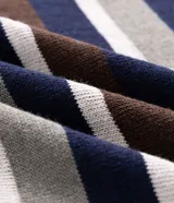 Remera de tejido de punto tricot con diseño de rayas horizontales en tonos azul marino, marrón, gris y blanco. Presenta cuello redondo, mangas cortas y terminaciones acanaladas.