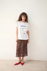 Remerón blanco oversize de algodón, con estampado frontal de estilo playero que incluye un cocodrilo, un paraguas de playa, una silla de playa y otros elementos.