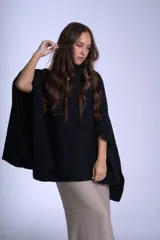 Poncho tejido color beige, con cuello alto y corte asimétrico.