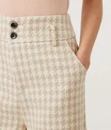 Short de tiro alto confeccionado en tejido tweed con estampado pied-de-poule. Presenta una cinturilla ancha con trabillas y un corte estructurado de estilo sastrero.