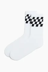 Medias de caña alta blancas, con diseño a cuadros negros en la parte superior acanalada.