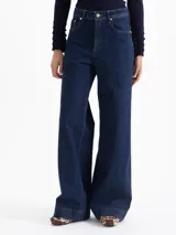 Jeans wide leg de denim azul oscuro, liviano y con leve elasticidad. De tiro medio y silueta amplia, con un aire pulido y versátil.
