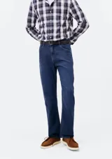 Pantalón de jean de corte slim, color azul clásico, con cierre de botón y cremallera, bolsillos laterales y traseros.