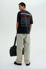 Remera negra de algodón de peso medio, corte holgado (Loose Fit), con cuello redondo. Estampado frontal con el logo de Guns N' Roses, una calavera con una rosa y una cadena, y el texto "Appetite for Destruction 1987-1988".