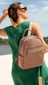 Mochila pequeña de símil cuero color negro, con bolsillo frontal con cierre, asa de mano y correas regulables.