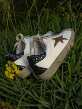 Championes urbanos Champion modelo Gian, color blanco con detalles en gris y estrella dorada en el lateral.