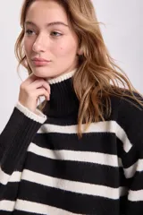 Buzo de punto con cuello alto, a rayas horizontales blancas y negras.