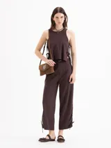 Pantalon de tiro medio color beige, confeccionado en twill, con fit relajado, pierna ancha estilo babucha, bolsillos laterales y traseros tipo ojal, y presillas en la cintura.