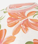 Blusa de calce entallado confeccionada en viscolycra con estampa floral en tonos rosados y verdes sobre fondo crema. Presenta cuello redondo y terminaciones de mangas cortas en tejido de punto acanalado de color rosado.